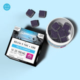 Green Roads Wildberry Delta-9 THC + CBD Relax Gummies box beside an open jar and loose purple gummies on a blue background.
