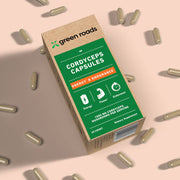 Green Roads Energy & Endurance Cordyceps Capsules box surrounded by capsules on a peach background, labeled 60 count.