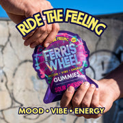 Hands opening a Ferris Wheel Sour Cherry gummies pouch outdoors, with the slogan ‘Ride the Feeling.