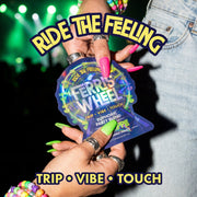 Hands with pink and green nails holding a Ferris Wheel Juicy Apple two-tablet pouch with green stage lights behind.