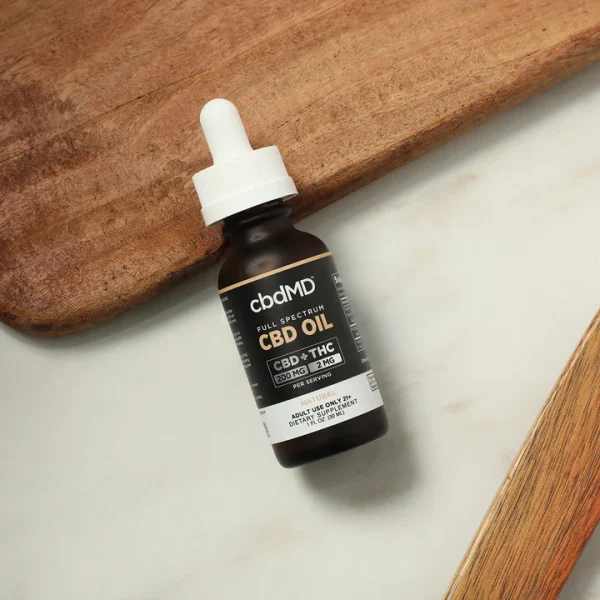 CBD Tincture - Full Spectrum 6000mg in a brown bottle set on a white and wood grained background