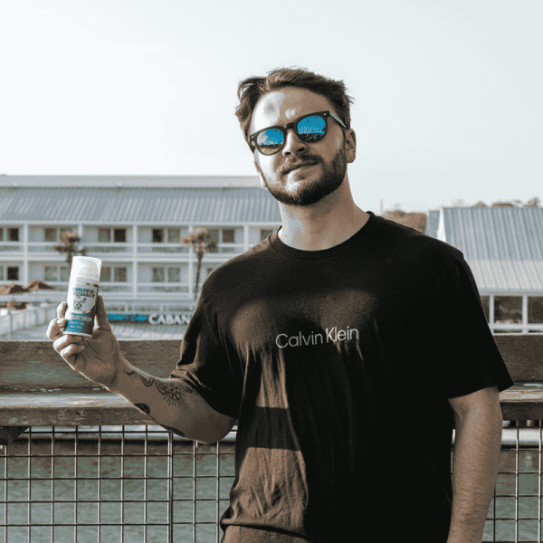 Man holding Cannabis Pharmacy CBD Cream outdoors, a 1500mg formula for muscle and joint pain relief