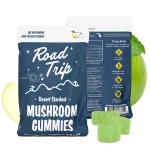 Road Trip Green Apple Mushroom Gummies pouch with floating green apple slices and gummies on a bright orange-yellow background.